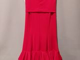 a red dress hanging on a hanger against a wall