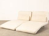 two white chaise loungers sitting on a concrete floor in a room