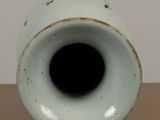 a white vase sitting on top of a wooden table