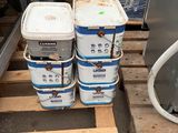 several buckets of water sitting on a pallet next to a television
