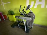 un gros plan d'une machine devant un mur orné d'une plante