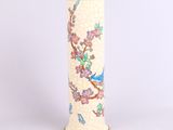 un vase sur lequel sont peints un oiseau et des fleurs