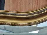 a mirror that has a gold frame on it