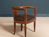 an image of a wooden chair with a leather seat on a carpeted floor