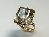 a close up of a gold ring with a green quartz stone