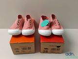deux paires de baskets roses posées sur une boîte