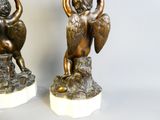 paire de figurines anciennes en bronze représentant un garçon et une fille assis sur un rocher