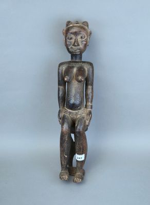 un gros plan sur une statue en bois représentant une personne torse nu