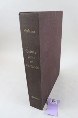 un vieux livre posé sur une table blanche, à côté d'une étiquette violette