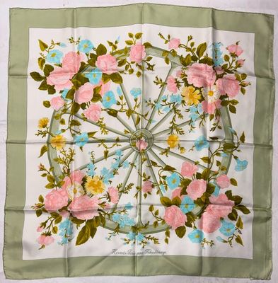 un foulard carré orné de fleurs roses et bleues sur fond vert