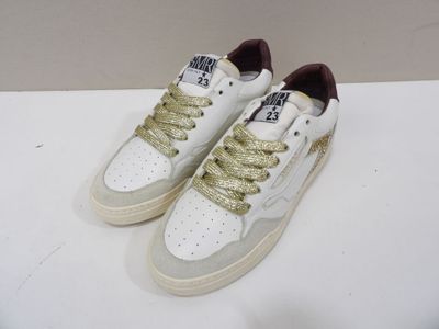 white sneakers with gold laces on them sitting on a white surface