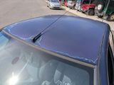 a car that has a broken windshield on the side of the road