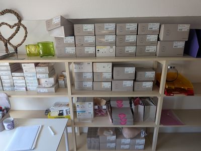 une étagère sur laquelle sont posées de nombreuses boîtes, dans une pièce