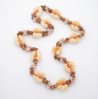 collier de perles avec des coquillages et des perles marron sur un fond blanc