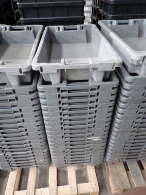 de nombreux conteneurs en plastique empilés sur une palette dans un entrepôt