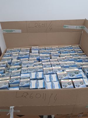 une boîte en carton remplie de liasses de billets, posée sur une table