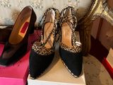 pair of black and leopard print shoes sitting on top of a stack of boxes