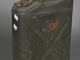 an old metal canister with a metal handle on a gray surface