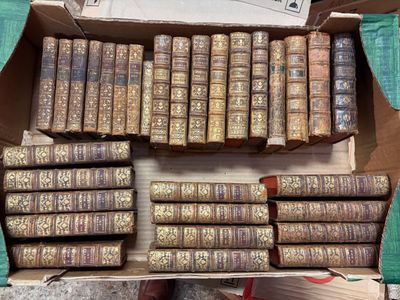 de nombreux vieux livres dans une boîte en carton posée par terre