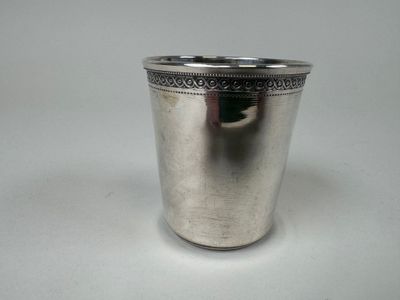une image représentant une coupe en argent posée sur une surface blanche