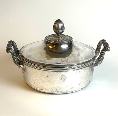 a silver casserole with a lid on a table
