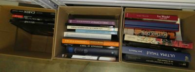 de nombreux livres qui se trouvent dans une boîte posée par terre