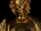 gold statue of a woman with hands up in the air