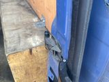 a close up of a blue truck door with a metal latch