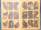 an open book with a picture of birds and letters on it