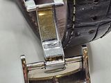 a close up of a watch on a white surface