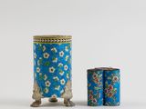 a blue and white vase with flowers on it next to a canister