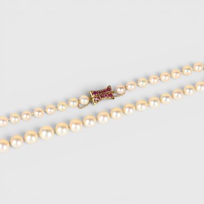 un gros plan sur un collier de perles muni d'un fermoir en or
