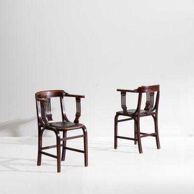deux chaises en bois assises l'une à côté de l'autre sur une surface blanche