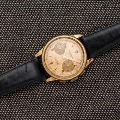 un gros plan d'une montre en or posée sur un tissu noir