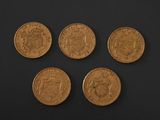 four different types of gold coins on a black surface