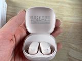 une personne tenant une paire d'AirPods dans la main