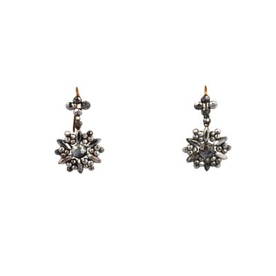 une photo d'une paire de boucles d'oreilles sur fond blanc