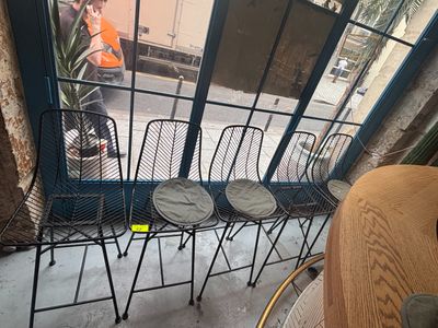 quatre chaises placées devant une fenêtre, sur le trottoir