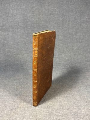 an old book sitting on top of a table next to a gray background