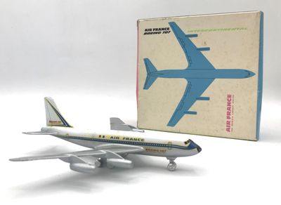 un petit avion en plastique posé devant une boîte