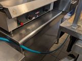 a commercial kitchen with stainless steel appliances and a blue hose