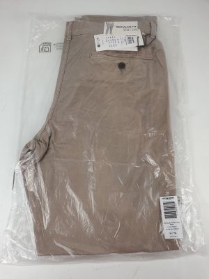 un pantalon kaki pour homme dans un sac en plastique posé sur une surface blanche