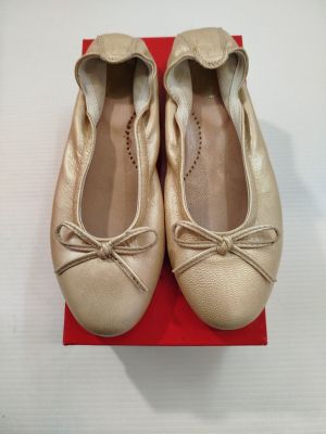 une paire de ballerines beiges posée sur une boîte rouge