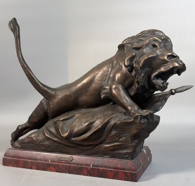 statue en bronze représentant un lion attaquant un autre lion, posée sur un socle en marbre