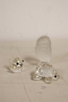 two clear glass figurines sitting on a table