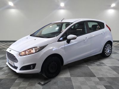 a white ford fiesta parked on a checkered floor in a garage