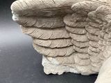 a statue of a bird that is sitting next to a shoe