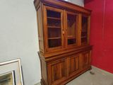 a wooden china cabinet in a room with a red wall
