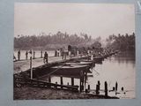 a black and white photo of a group of people standing on a dock