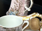 une tasse et une soucoupe posées sur une assiette, avec une théière à côté